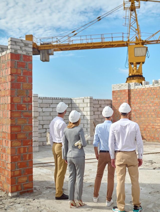 four-people-protective-helmets-inspecting-building-area_259150-60517